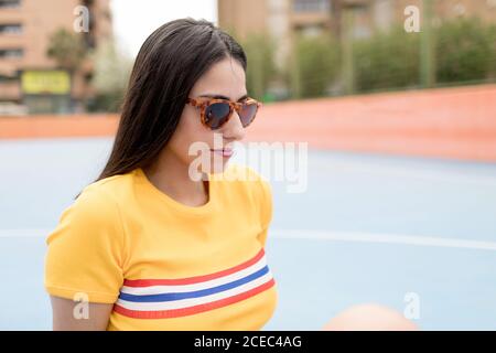 Jeune femme assise sur un terrain de sport Banque D'Images