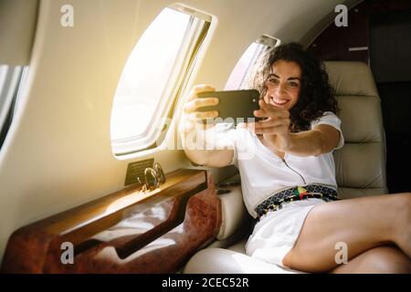 Femme faisant le selfie dans l'avion Banque D'Images