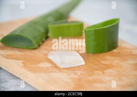 Morceaux de Vera d'aloès vert frais avec chair blanche sur fond clair. Banque D'Images