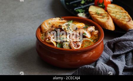 Soupe de crevettes et poulpe près de toasts et spoon Banque D'Images