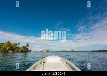 Vue sur le bateau blanc voile dans l'eau calme de l'eau bleue avec le bord de mer exotique à la lumière du soleil, Panama Banque D'Images