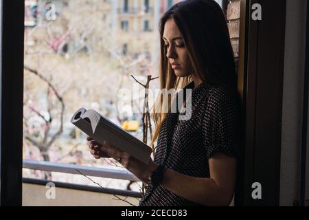 Femme avec livre sur le balcon Banque D'Images