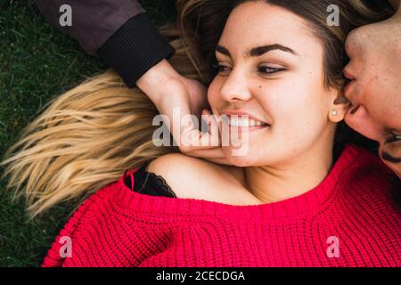 Couple heureux aimant posant sur l'herbe Banque D'Images