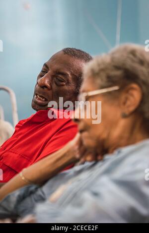 LA HABANA, CUBA - 6 NOVEMBRE 2018: Vue latérale des femmes et des hommes afro-américains âgés assis et dormant dans la chambre à Cuba Banque D'Images