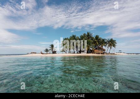 Vue pittoresque sur les arbres tropicaux, plage de sable et construction entre mer et ciel bleu dans les îles de San Blas, Panama Banque D'Images