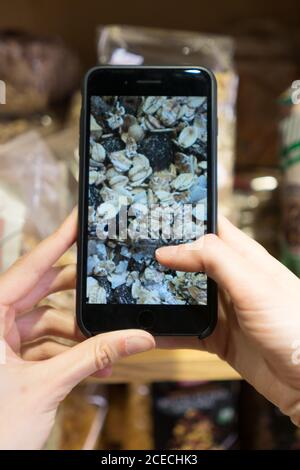 Rognez la vue rapprochée de la personne photographiant des muesli sur son smartphone Banque D'Images