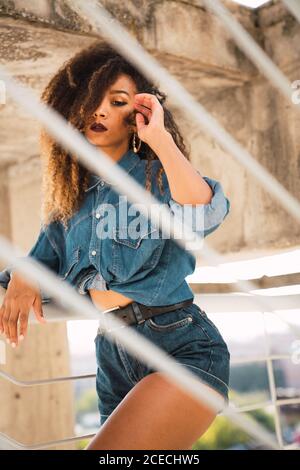 Femme afro-américaine debout près du mur Banque D'Images