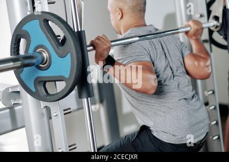 Homme musculaire mature faisant des squats avec grande barbell avec lourd plaques de poids Banque D'Images