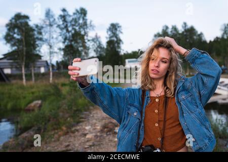 Jeune femme faisant le selfie sur la côte du lac Banque D'Images