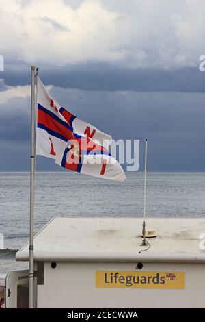 Drapeau RNLI survolant Lifeguard Station, Sandsend, Whitby Banque D'Images