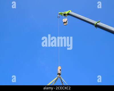 Grue lourde complètement déployée tandis que son palan et sa chaîne se balançant dans l'air. Banque D'Images