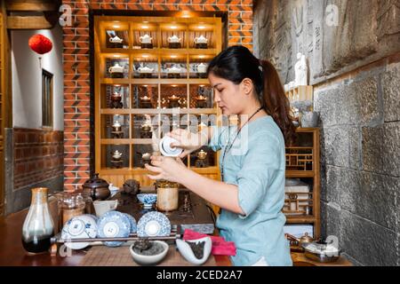 Jeune femme asiatique préparant des préparations et préparant du thé oriental Banque D'Images