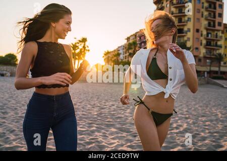 De belles amies qui s'exécutent sur la plage Banque D'Images
