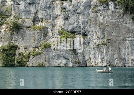 Couple dans un bateau à rames sur le lac Koenigssee en appréciant pittoresque paysage en face d'une immense face de roche Banque D'Images