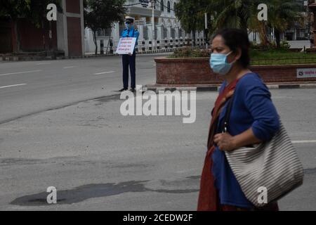 Katmandou, Népal. 1er septembre 2020. Une femme portant un masque de marche à côté d'un mannequin masqué portant une tenue de police de la circulation est photographiée le long de la route vide au cours du 12ème jour du deuxième confinement comme mesure préventive contre la propagation de la pandémie de coronavirus au Népal.Népal police place 22 mannequins habillés comme la police de la circulation limiter les violations de la circulation en cas de pandémie du coronavirus. Crédit : SOPA Images Limited/Alamy Live News Banque D'Images