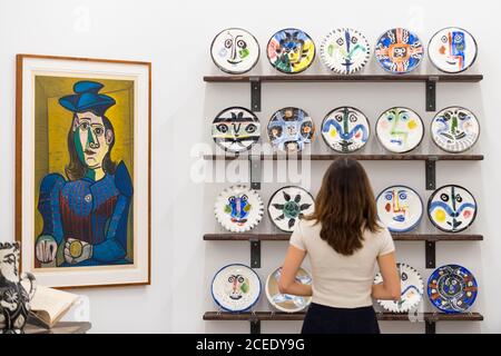 Londres, Royaume-Uni. 1er septembre 2020. Un membre du personnel pose avec (de L à R) 'Femme assise (Dora Maar) [Femme assise (Dora Maar)]', 1955, et 'l'ensemble complet de 20 'plaques de visite', 1963, tous par Pablo Picasso. Avant-première de l'atelier Picasso, une nouvelle exposition recréant le studio de Pablo Picasso à Cannes avec ses dessins, ses gravures, ses céramiques et ses meubles. Le spectacle est à la galerie Bastian à Mayfair du 3 septembre au 31 octobre 2020. Les visiteurs devront porter un masque facial et pratiquer la distanciation sociale. Credit: Stephen Chung / Alamy Live News Banque D'Images