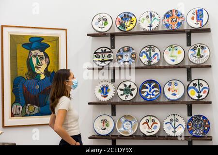 Londres, Royaume-Uni. 1er septembre 2020. Un membre du personnel pose avec (de L à R) 'Femme assise (Dora Maar) [Femme assise (Dora Maar)]', 1955, et 'l'ensemble complet de 20 'plaques de visite', 1963, tous par Pablo Picasso. Avant-première de l'atelier Picasso, une nouvelle exposition recréant le studio de Pablo Picasso à Cannes avec ses dessins, ses gravures, ses céramiques et ses meubles. Le spectacle est à la galerie Bastian à Mayfair du 3 septembre au 31 octobre 2020. Les visiteurs devront porter un masque facial et pratiquer la distanciation sociale. Credit: Stephen Chung / Alamy Live News Banque D'Images