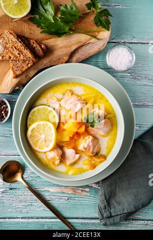 Vue de dessus d'une délicieuse soupe de saumon saine avec de la crème à base de plantes, des carottes et des pommes de terre Banque D'Images