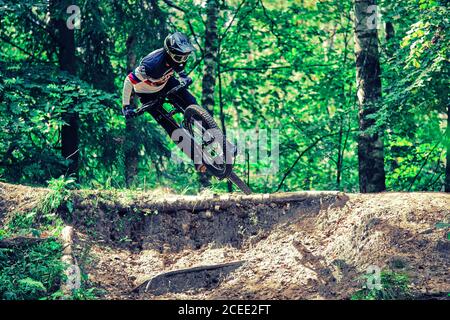 Russie, Moscou - 29 août 2020 : un jeune garçon sautant avec son VTT en forêt. Conduite professionnelle en descente. Vélo dans la nature. Cool athlète en cy Banque D'Images