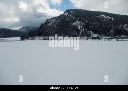 Paysage enneigé avec des montagnes et des maisons rouges en Norvège près Bergen vue depuis le train Bergensban Banque D'Images