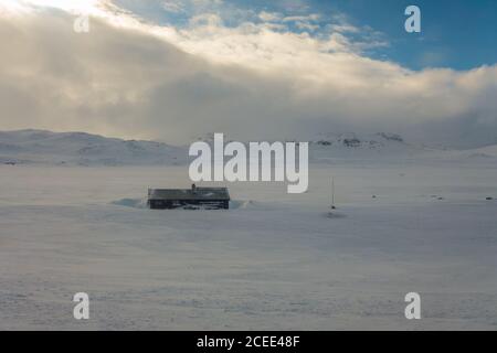 Paysage enneigé avec des montagnes et des maisons rouges en Norvège près Bergen vue depuis le train Bergensban Banque D'Images