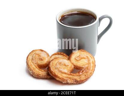 Cœur de pâte feuilletée émaillé de sucre caramélisé et d'une tasse de café isolé sur blanc Banque D'Images