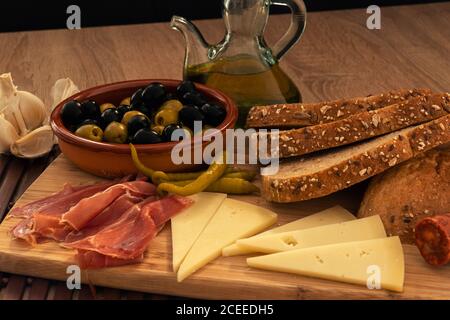 Table en bois avec quelques plats typiques espagnols dans une obscurité scène Banque D'Images