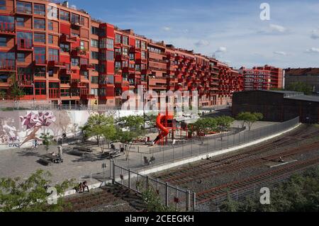 Un nouveau bâtiment à Berlin Schöneberg conçu avec une architecture moderne, avec une aire de jeux, une piste cyclable et d'anciens chemins de fer en face Banque D'Images