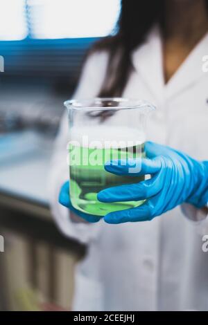 Femme en manteau blanc tenant une tasse avec du liquide jaune Banque D'Images