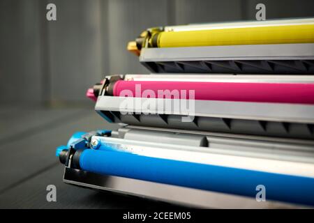 Remplacement du toner pour imprimante laser couleur cyan, magenta et jaune sur fond de bois gris Banque D'Images