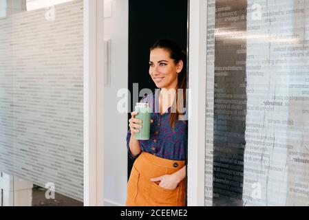 Femme souriante avec une tasse au bureau Banque D'Images