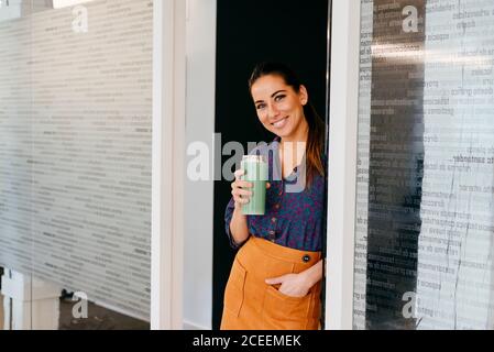 Femme souriante avec une tasse au bureau Banque D'Images