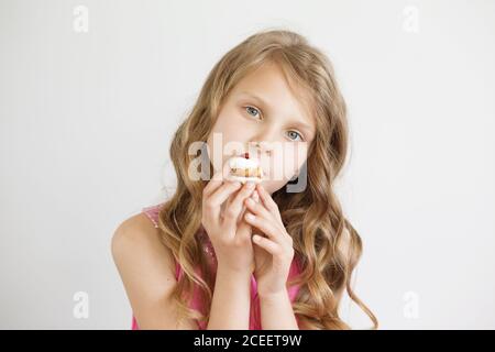 Belle petite fille tenant un délicieux gâteau appétissant Banque D'Images