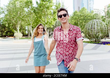 Couple tenant les mains et marchant dans la rue Banque D'Images