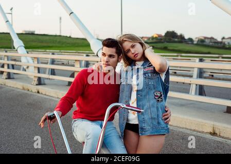 Jeune couple debout sur le pont avec vélo d'époque Banque D'Images