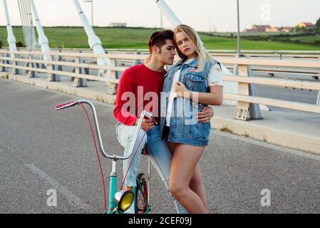 Jeune couple debout sur le pont avec vélo d'époque Banque D'Images