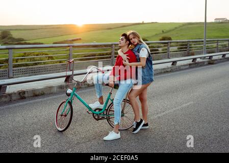 Jeune couple debout sur le pont avec vélo d'époque Banque D'Images