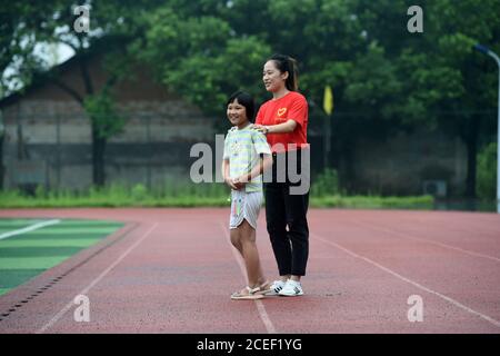 (200901) -- HEFEI, 1er septembre 2020 (Xinhua) -- lu Suzi (L) joue avec un bénévole sur un site de réinstallation dans le comté de Feidong, Hefei, province d'Anhui en Chine orientale, le 28 juillet 2020. Lu Suzi, né en 2011, est un élève de l'école primaire dans le comté de Feidong. En juillet, sous la menace de graves inondations, elle et sa famille ont été évacuées vers un lieu de réinstallation sûr, où elles ont reçu des soins et une attention méticuleuses de la part de bénévoles. Au fur et à mesure que les eaux de crue s'estompage, la vie de lu Suzi a commencé à revenir à la normale. L'école centrale de la zone scolaire de Changlinhe a officiellement ouvert lundi et lu, qui est devenu un étudiant de quatrième année, Banque D'Images