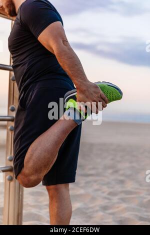 Jeune femme indépendante afro-américaine concentrée avec cheveux courts teints dans des vêtements élégants assis sur un banc en bois dans le parc et travaillant à distance Banque D'Images