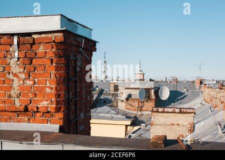 Ancienne cheminée en brique sur un toit de bâtiment résidentiel avec espace de copie, antenne parabolique ou 4g Banque D'Images