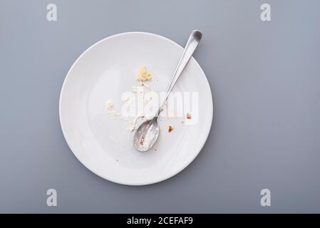 Assiette blanche avec chapelure et crème après gâteau sucré, vue de dessus Banque D'Images