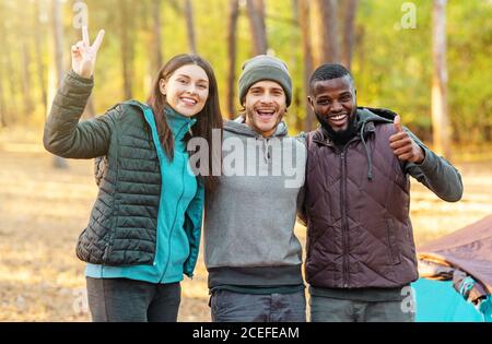 Jeunes randonneurs frais posant au-dessus du camp en forêt Banque D'Images