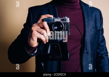 Jeune homme dans un studio équipé d'un appareil photo vintage Banque D'Images