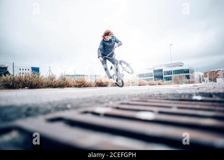 Un jeune homme pratique avec un vélo BMX. Banque D'Images