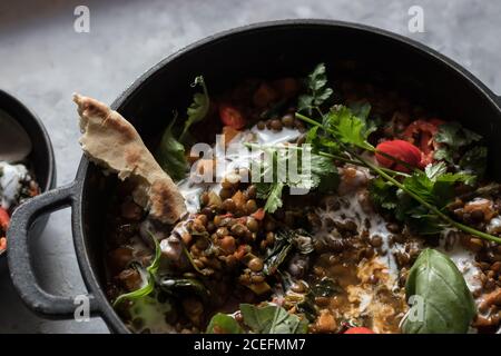 Bol près du pot avec ragoût de lentilles et patate douce curry Banque D'Images