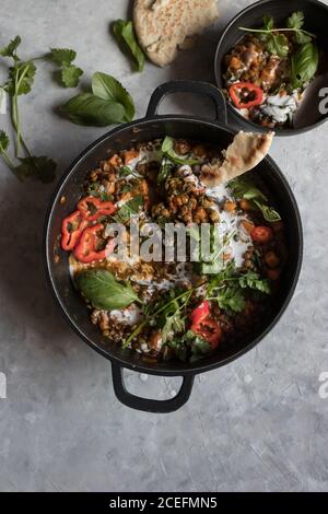 Bol près du pot avec ragoût de lentilles et patate douce curry Banque D'Images