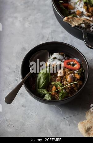 Bol près du pot avec ragoût de lentilles et patate douce curry Banque D'Images