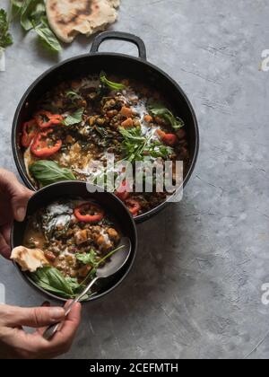 Bol près du pot avec ragoût de lentilles et patate douce curry Banque D'Images