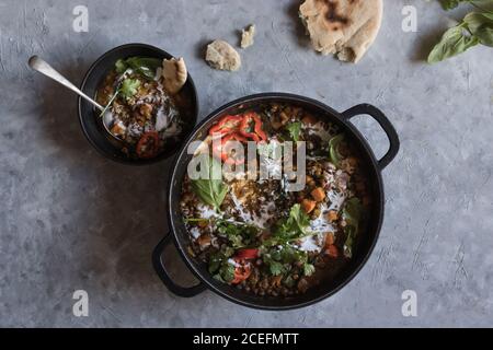 Bol près du pot avec ragoût de lentilles et patate douce curry Banque D'Images