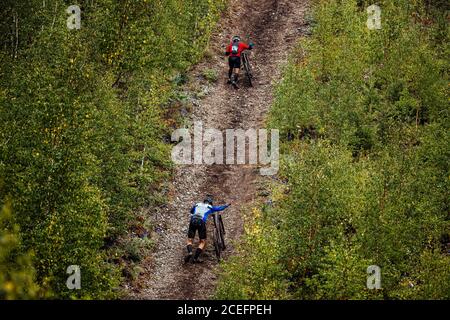 deux athlètes cyclistes avec des vtt qui marchent en amont de la forêt piste Banque D'Images